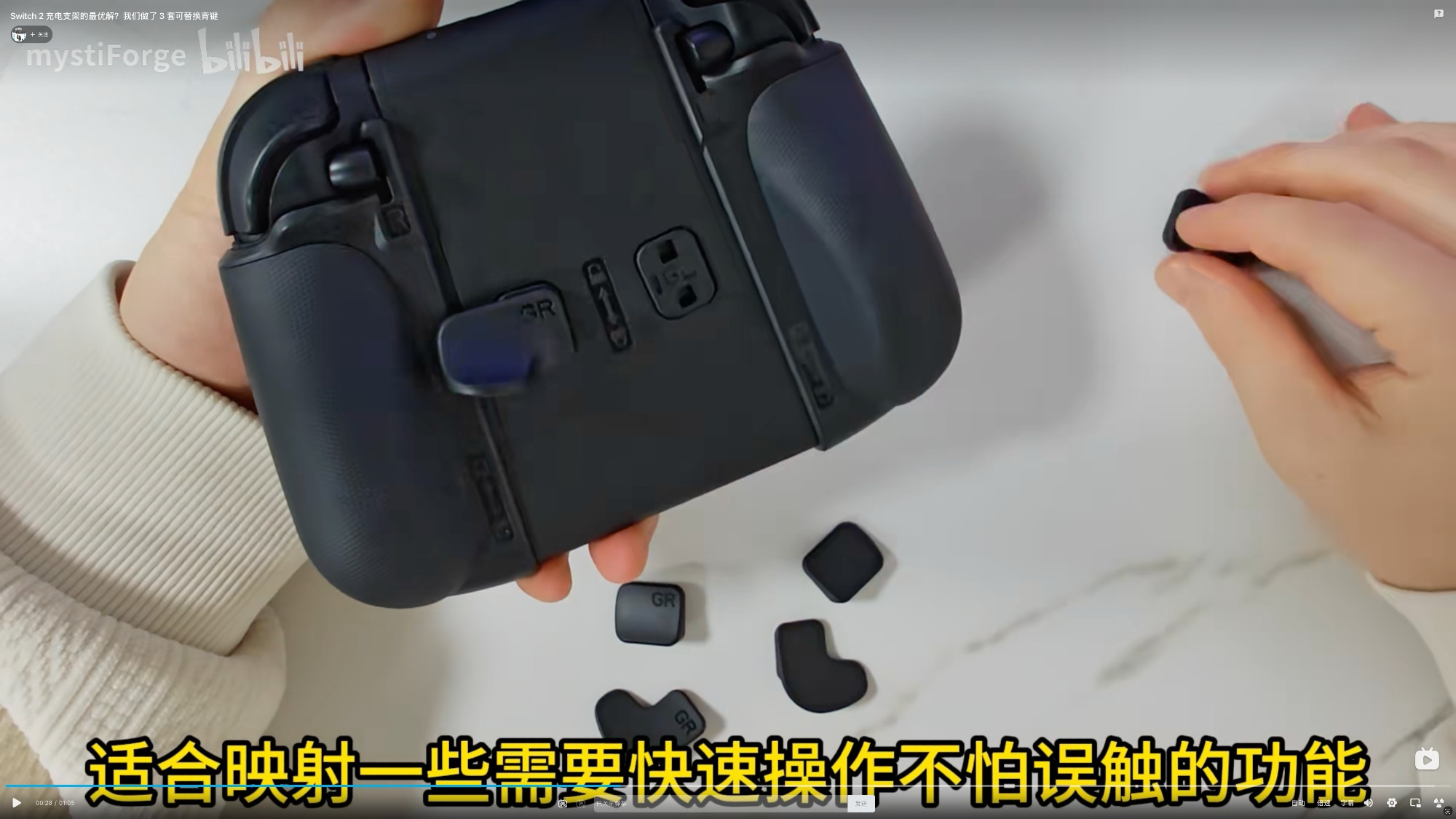 Screenshot of MystiForge Bilibili video, showing the GL/GR buttons on the back side of the charging grip with 3 swappable sets of button faces