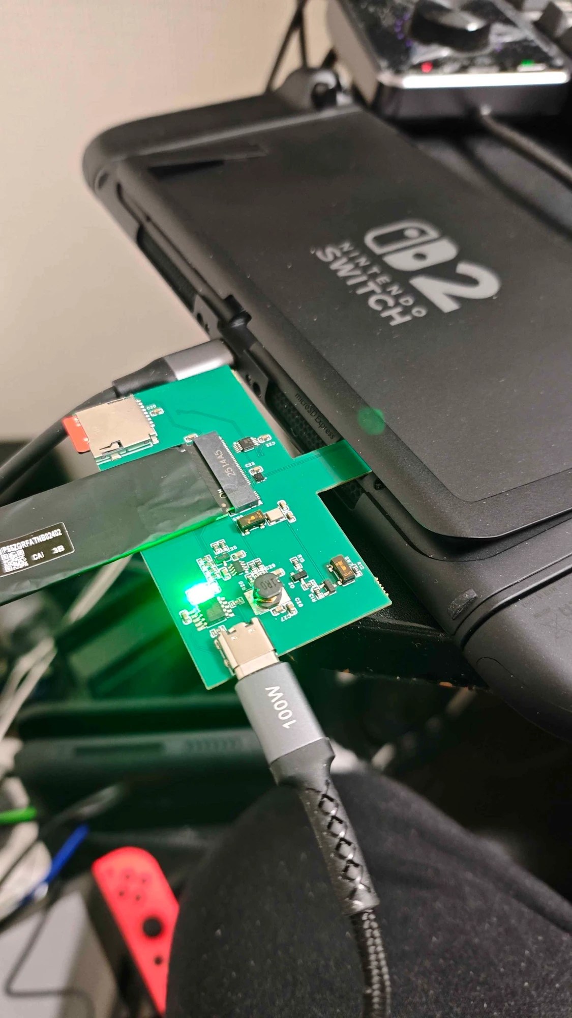 Photo of a custom PCB, SSD, and microSD Express Card, plugged into a Switch 2