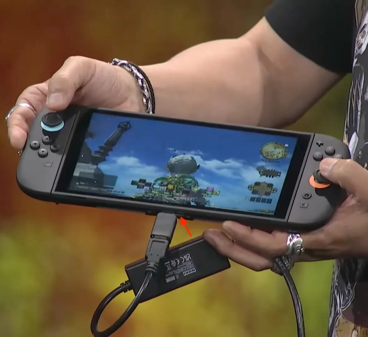 Screenshot of Yoshi-P’s keynote at the FINAL FANTASY XIV Fan Festival 2026 in Anaheim, showing him holding a Switch 2 devkit BEE-056