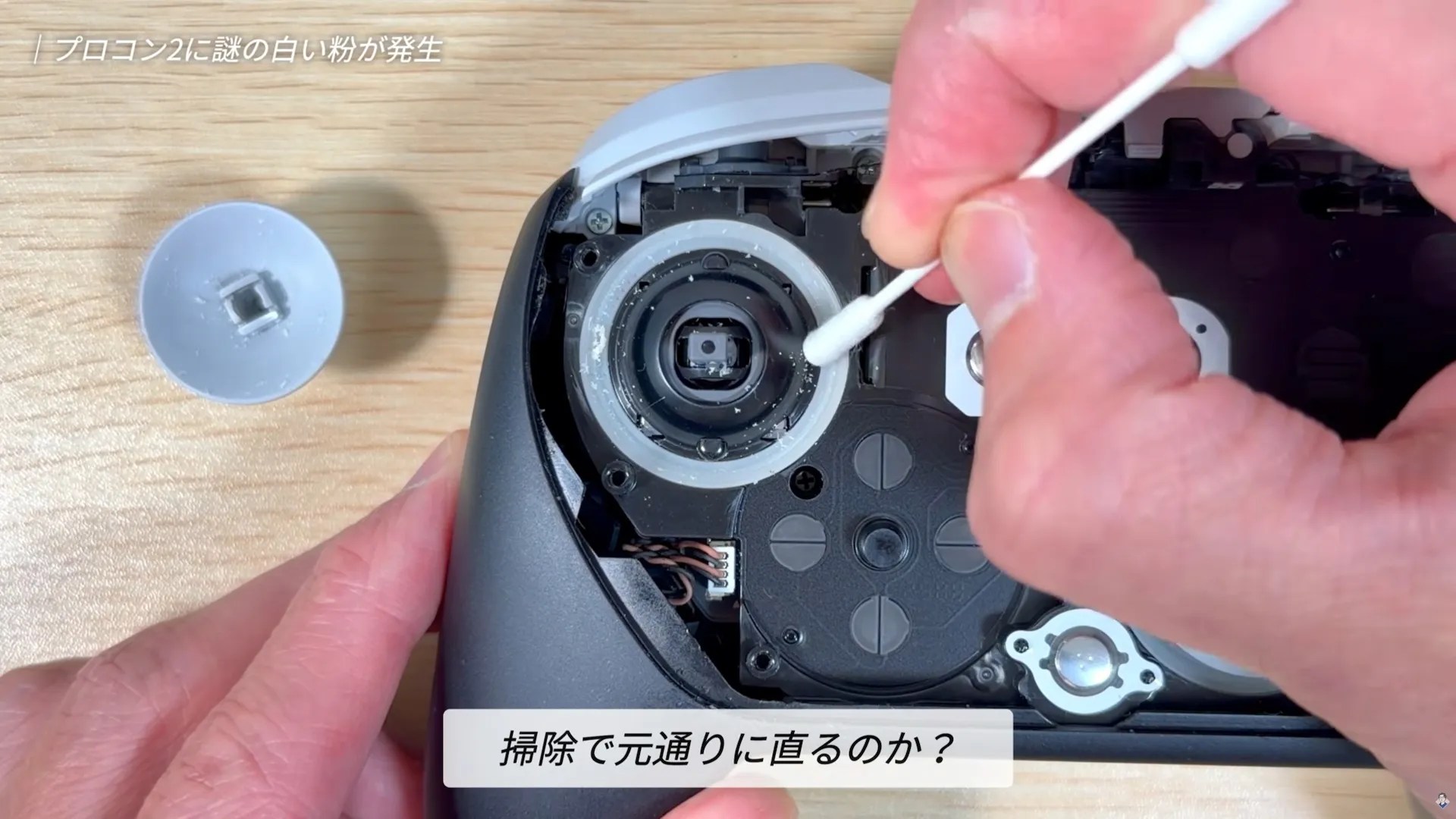 Screenshot of the YouTube video, showing the creator cleaning the flakes off the stick with a cotton swab