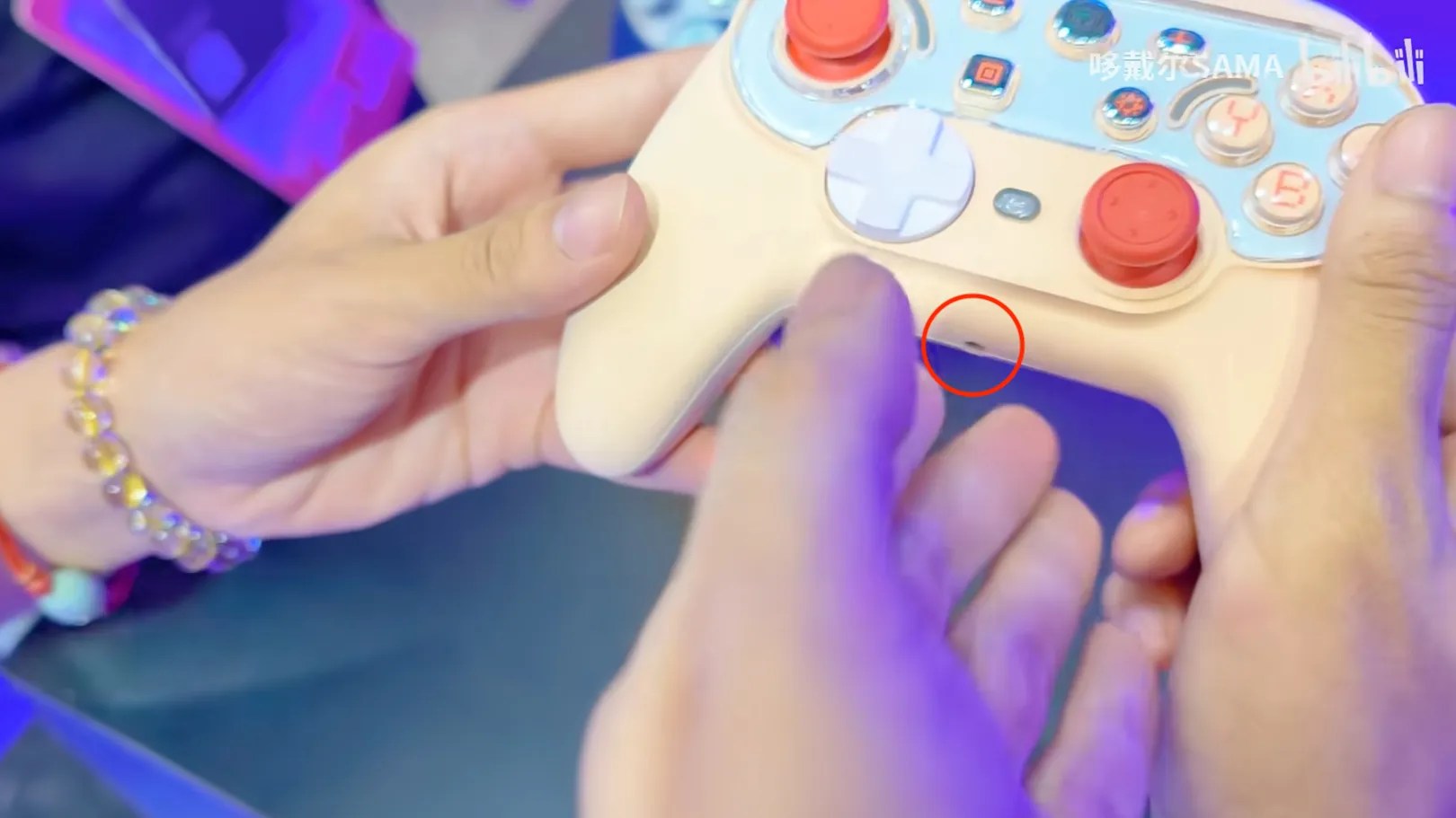 Photo of NYXI NS01 (probably not the product name but a model number), a Pro Controller 2 replacement, light peach color, 45-degree view with an audio jack visible https://www.bilibili.com/video/BV1LT3X6BER7/