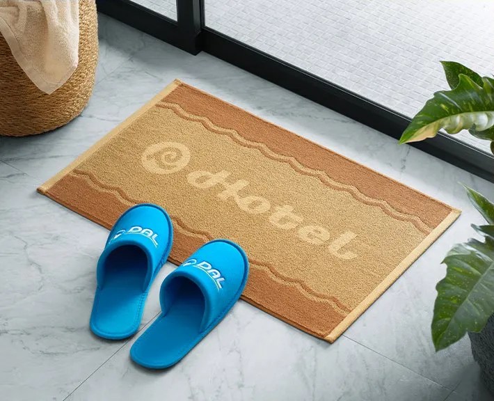Photo of the ACNH Resort Hotel merch, including DAL slippers and Hotel floor mat