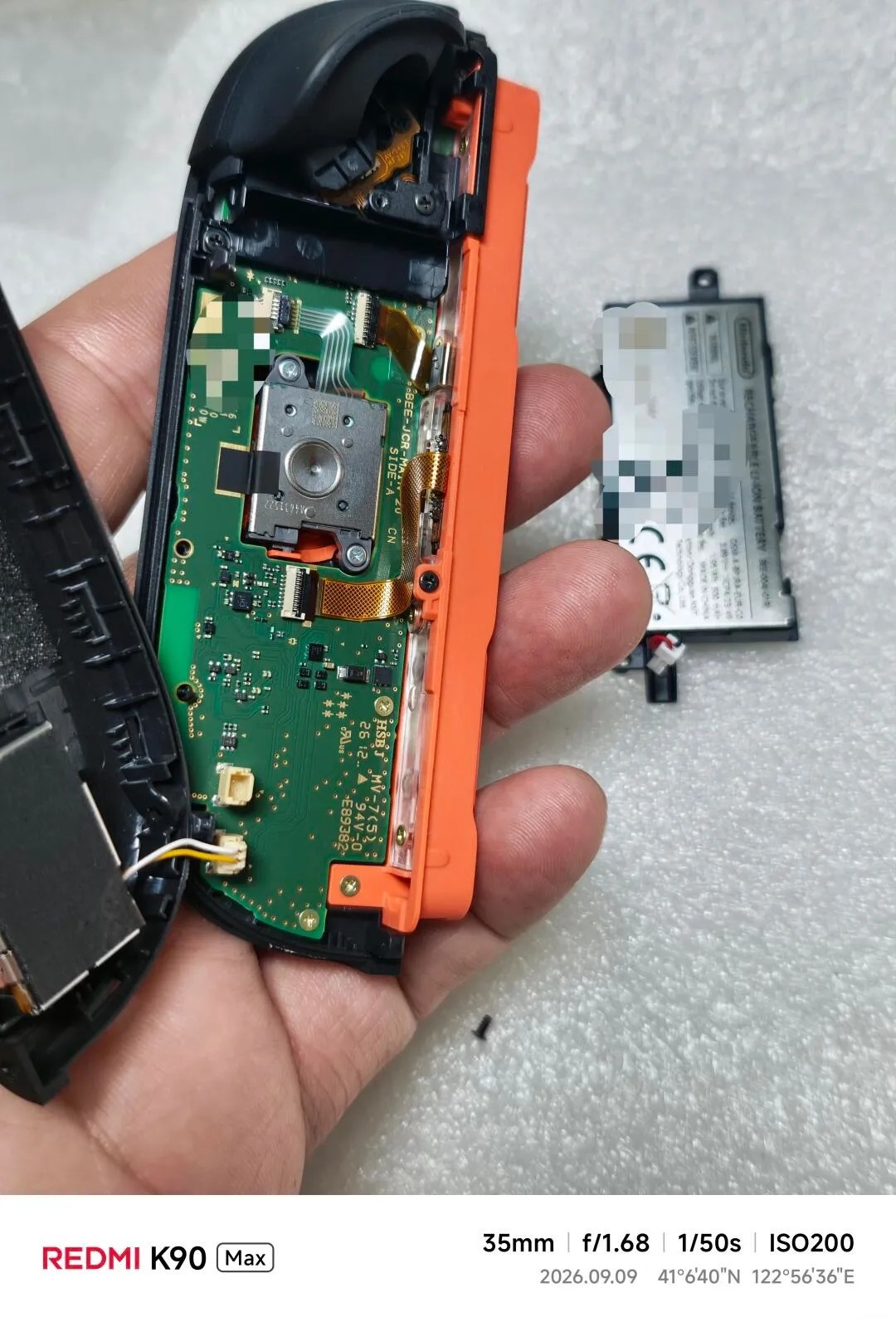 Photo of partially disassembled Joy-Con 2 (EU version), with the battery + frame removed
