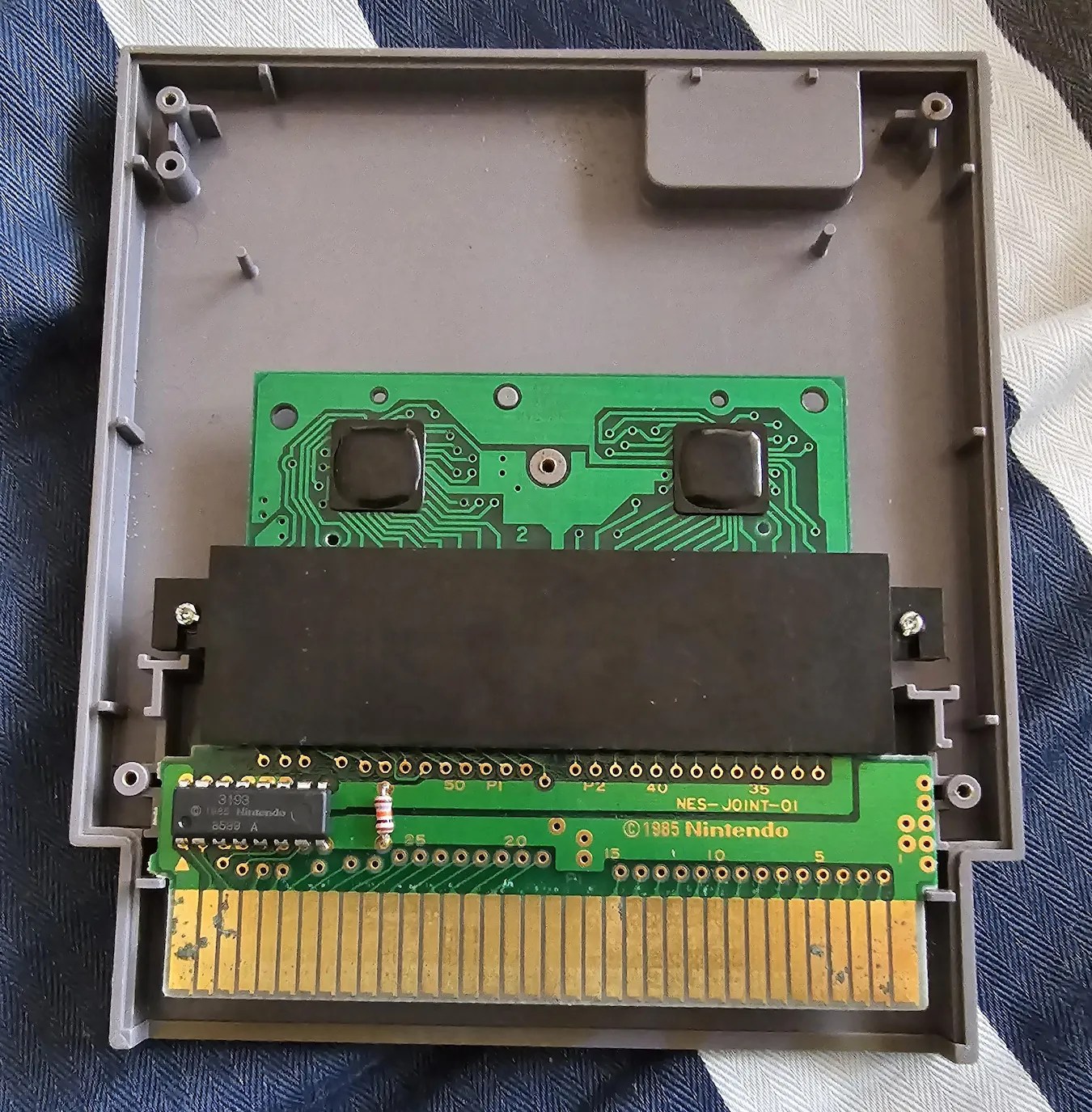 Interior photo of a 1985 NES cartridge (Pinball game), showing a 60-pin Famicom board plugged into a 60-to-72-pin adapter https://www.reddit.com/r/gamecollecting/comments/1d93aki/got_my_first_famicom_to_nes_converter_nes_game/